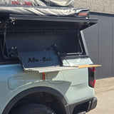 Alu-Cab fold-out table with integrated bamboo cutting board